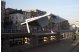 Auvent pour l’arrêt du tram Porte-de-Flandre, à Bruxelles. Le dispositif se pince sous le parapet du canal. La sous-face réfléchit l’eau en contrebas. Par MSA architectes (2014). - Crédit photo : DR  