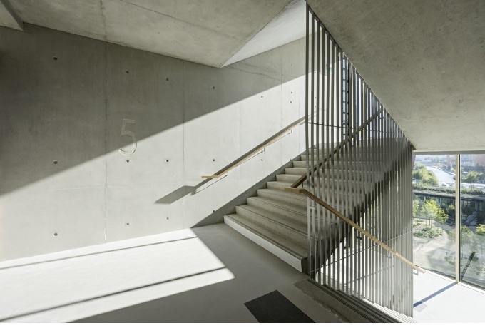 Les escaliers sont situés en façade et largement vitrés sur l’extérieur. Ils apportent de la convivialité, favorisent les échanges et permettent des économies d’énergie concrètes et quotidiennes sur les ascenseurs. <br/> Crédit photo : HURNAUS Hertha 