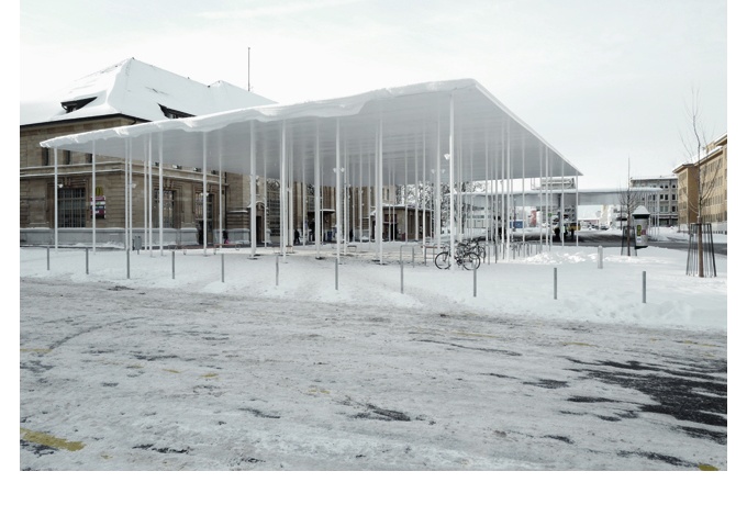 Le couvert polyvalent sous la neige et le bâtiment de la gare à l’arrière-plan.<br/> Crédit photo : Frundgallina -