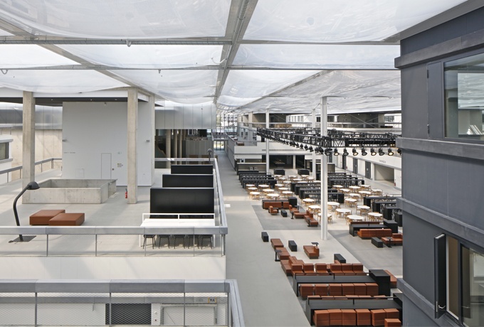 Vue intérieure sous un ciel synthétique en ETFE. Le bloc de l'administration conserve sa couleur noire.