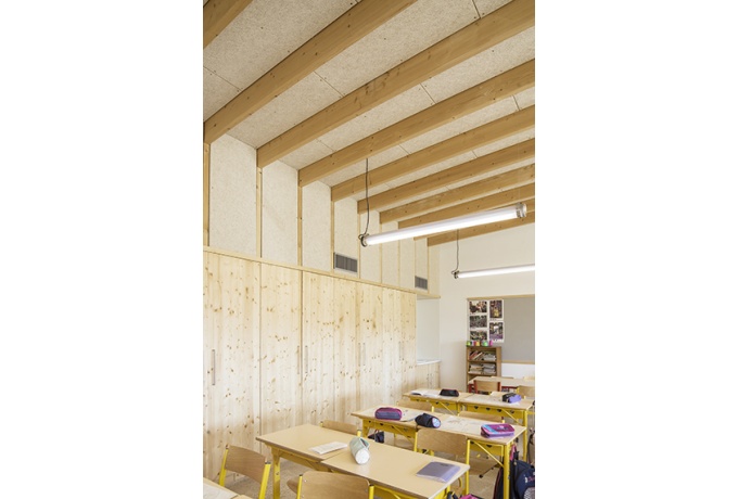Salle de classe, sols en béton poncé et charpente en bois<br/> Crédit photo : HENRION William