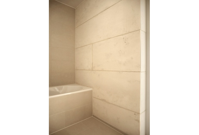 Une salle de bains. Le jointoiement marqué des blocs contribue à régler les espaces intérieurs<br/> Crédit photo : CAILLE Emmanuel