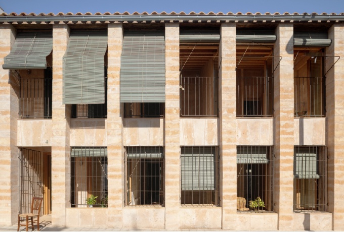 la structure verticale composée de piliers en pierre de marès se libère du mur sur la façade côté rue, Carrer Salvador Espriu 37.<br/> Crédit photo : VILLABA Milena
